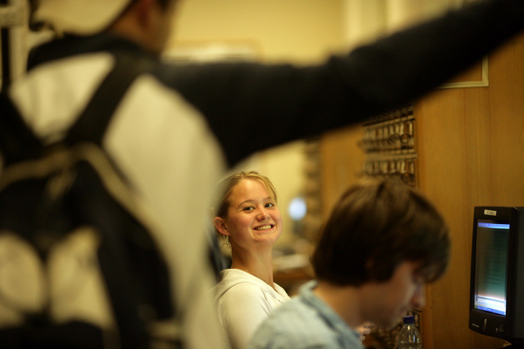 A student smiles as someone approaches