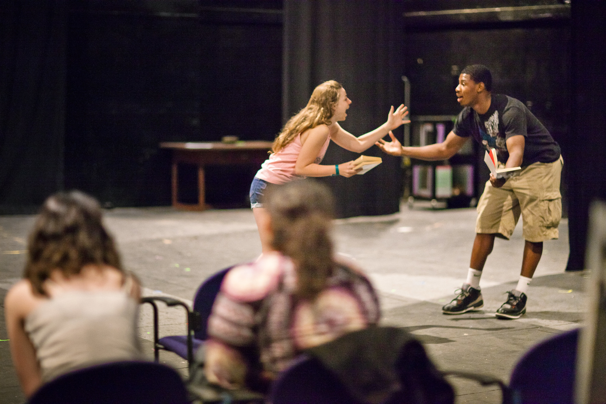 Two students rehearse a scene while others watch.